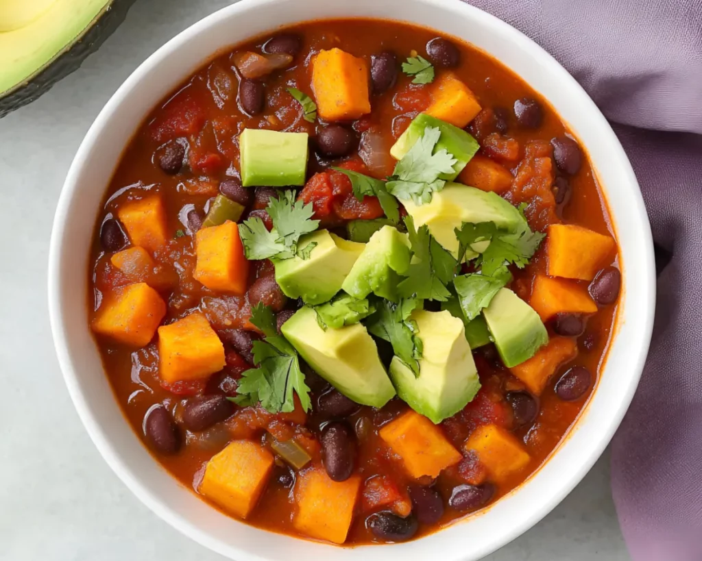 Bowl of sweet potato chili with avocado and cilantro