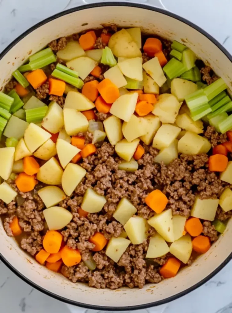 Cheeseburger soup ingredients before stirring in a white pot