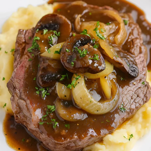 Plated Slow Cooker Round Steak and Gravy with mashed potatoes