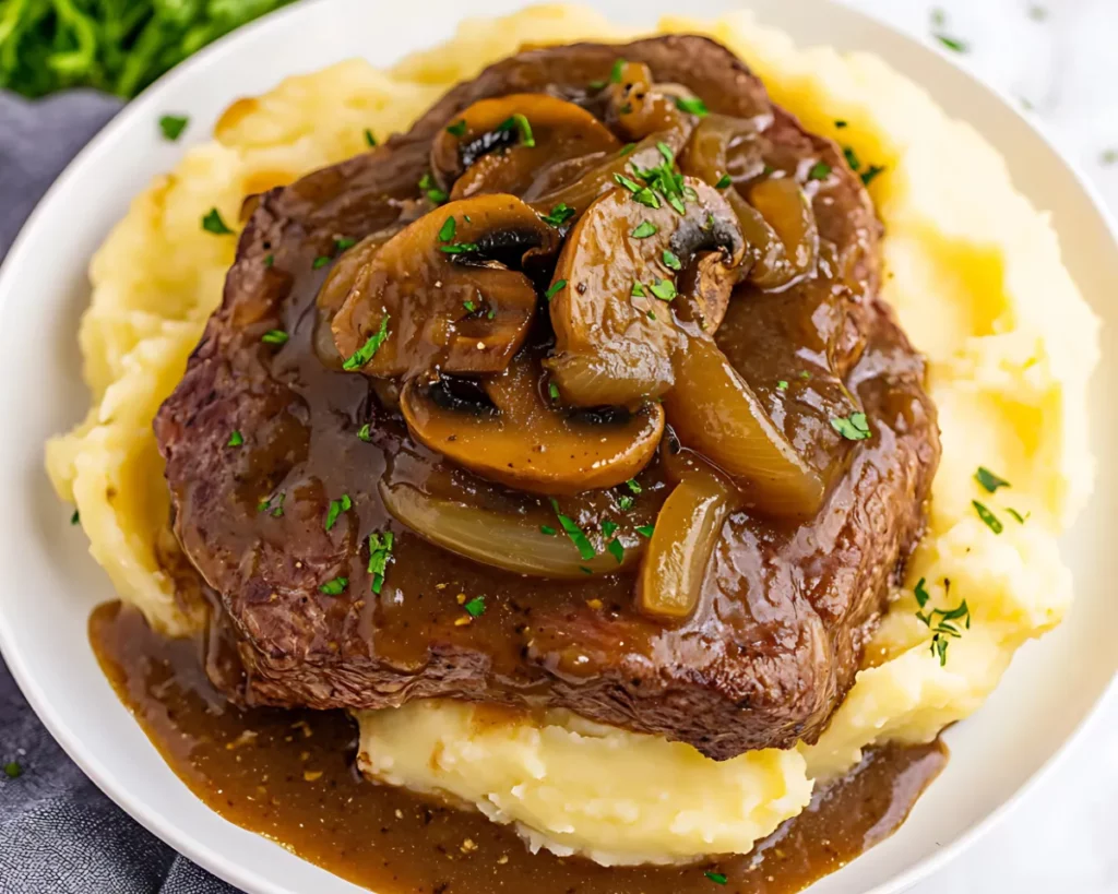 Plated Slow Cooker Round Steak and Gravy with mushrooms and onions