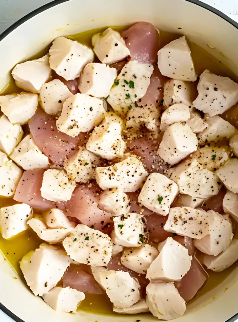 Raw chicken pieces seasoned in a pot