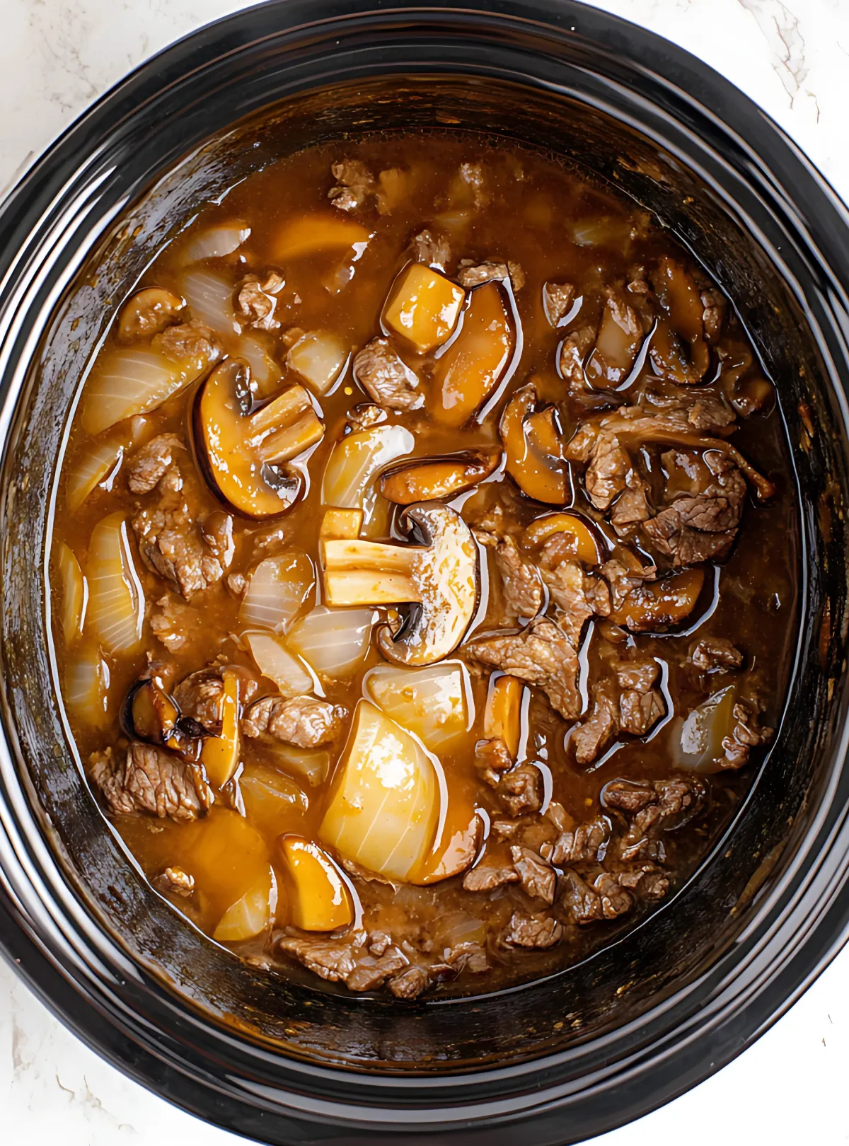 Slow Cooker Round Steak and Gravy with chunks of beef and onions