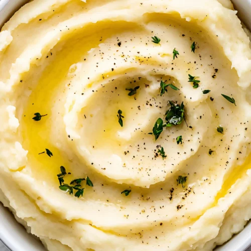 Smooth mashed potatoes with butter and herbs