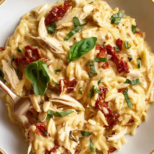 Finished marry me chicken orzo with basil leaves in a bowl