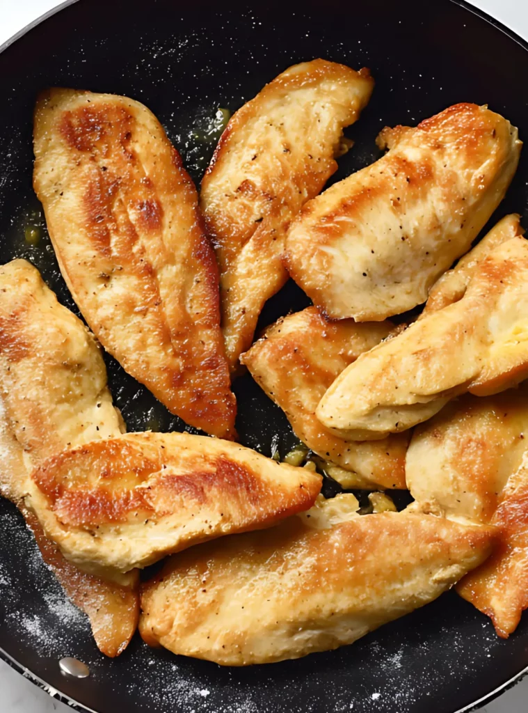 Golden seared chicken fillets in a skillet