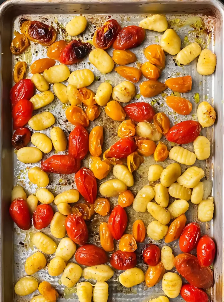 Roasted gnocchi with cherry tomatoes on baking tray