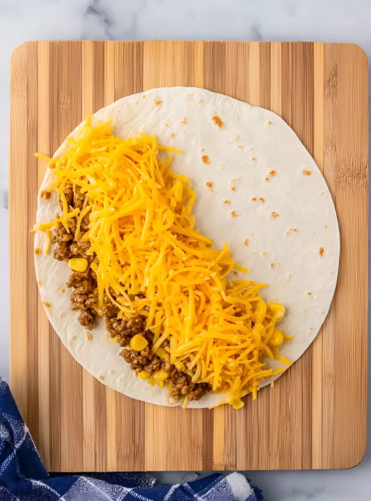 Tortilla topped with beef and shredded cheese
