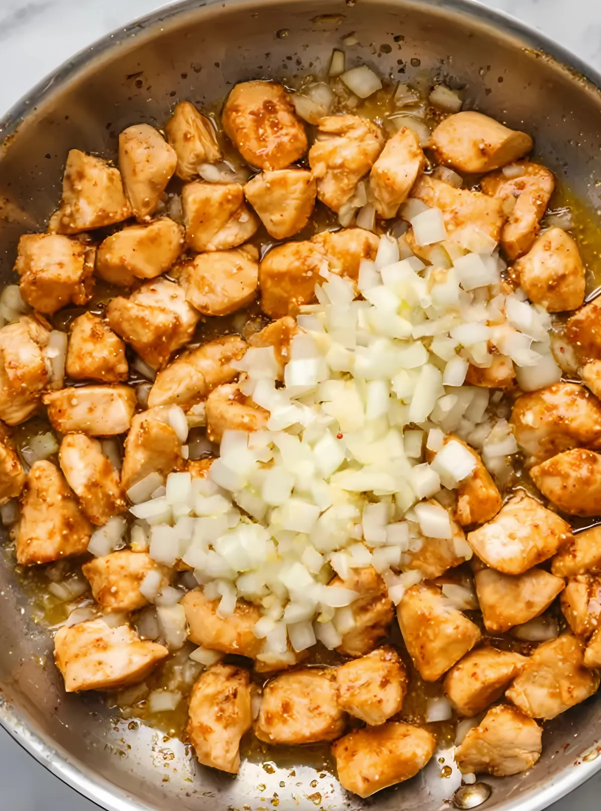 Cooked chicken with onions in skillet