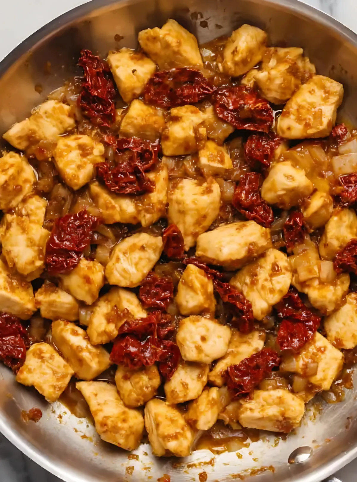 Cooked chicken with sundried tomatoes in skillet