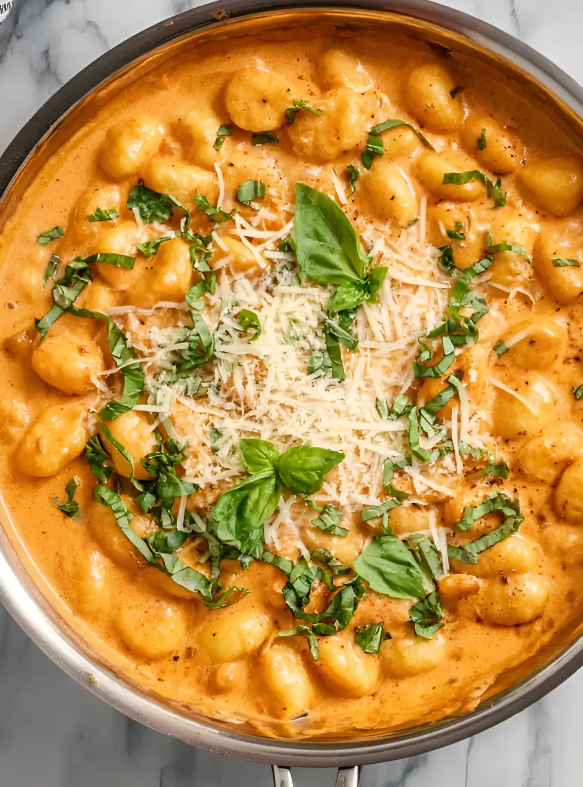 Creamy chicken gnocchi in white bowl with basil