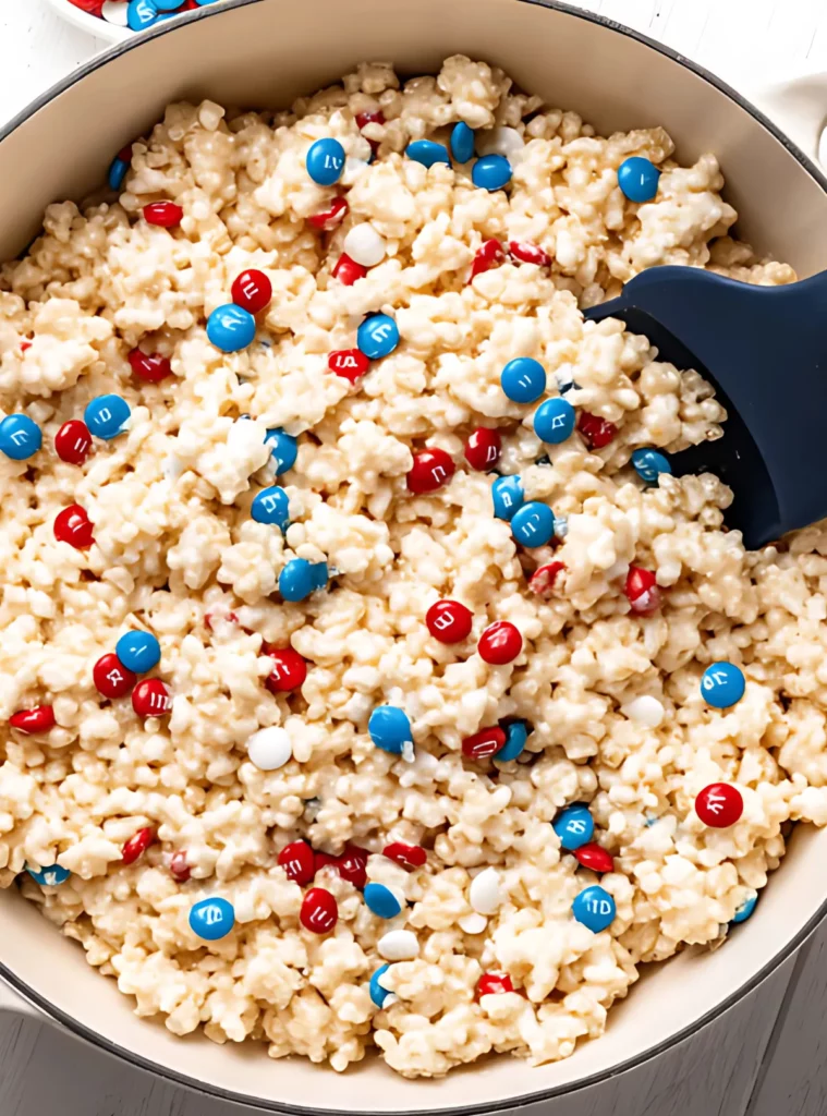 M&M rice krispie mixture in a large pot before setting