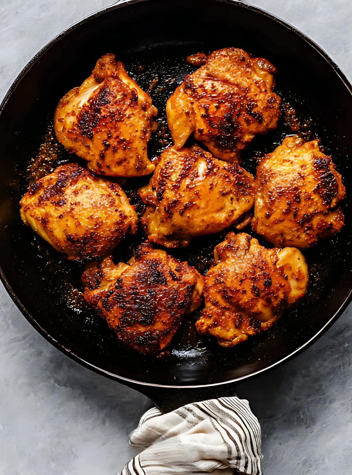 Seasoned chicken thighs in a cast iron skillet