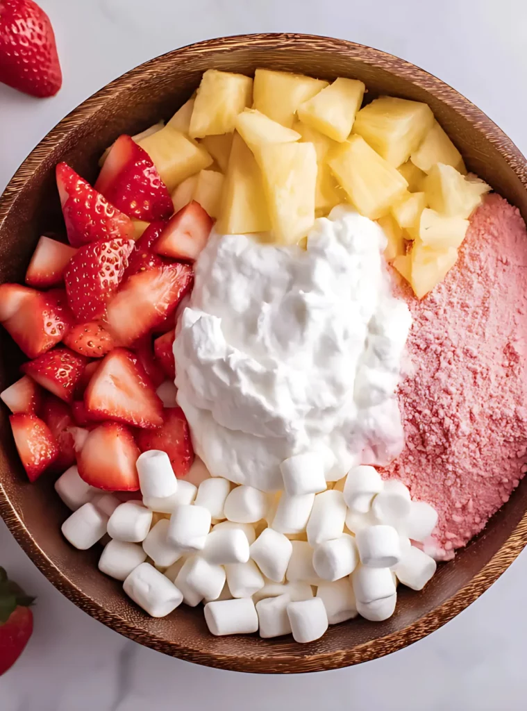 Unmixed ingredients for strawberry fluff in a wooden bowl