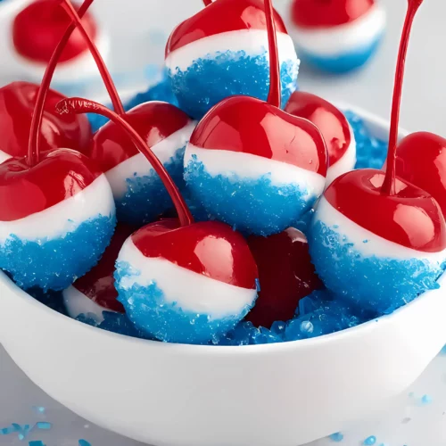 cherries in white bowl with blue sugar