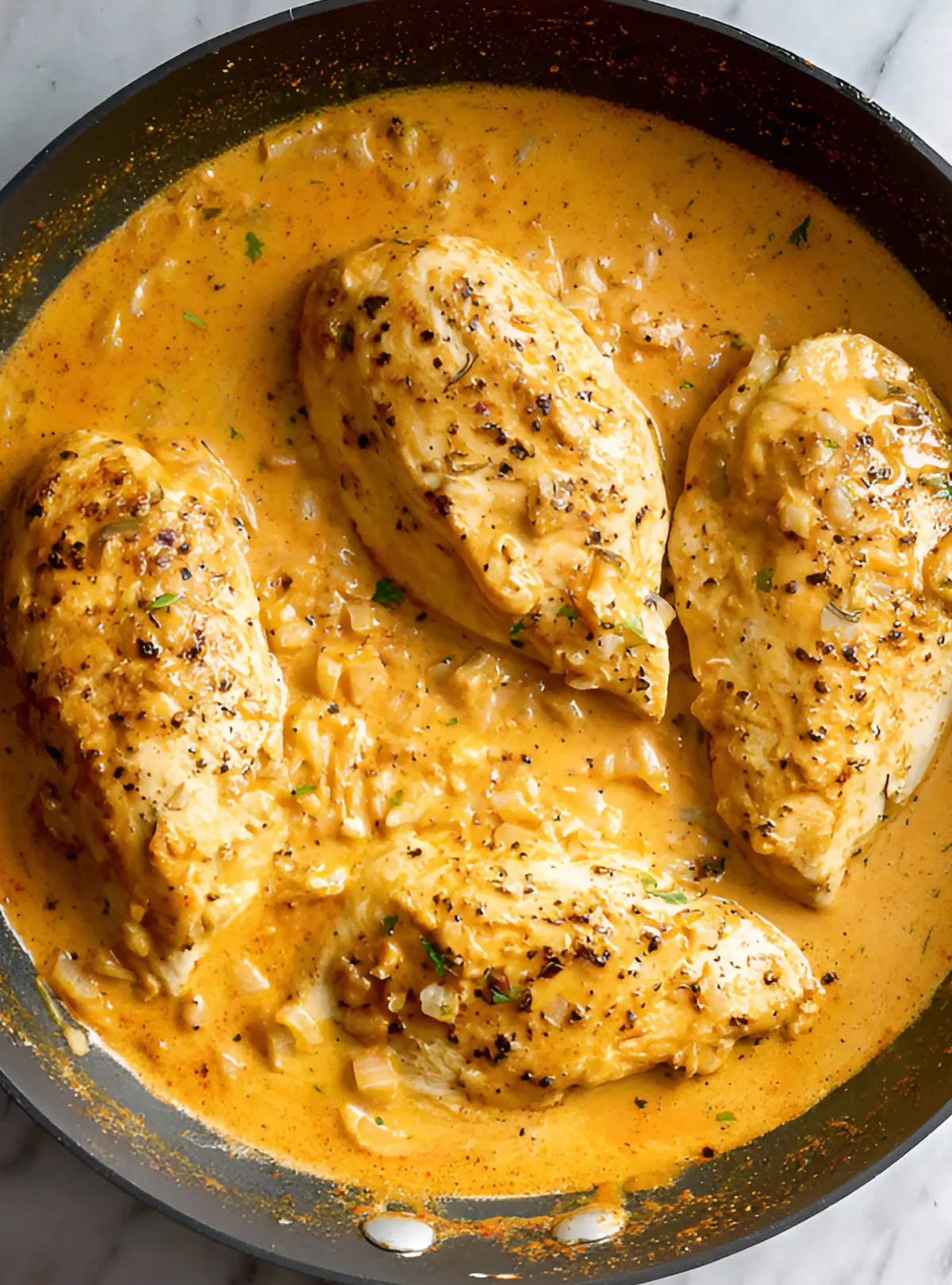 creamy chipotle chicken with onion bits in orange sauce