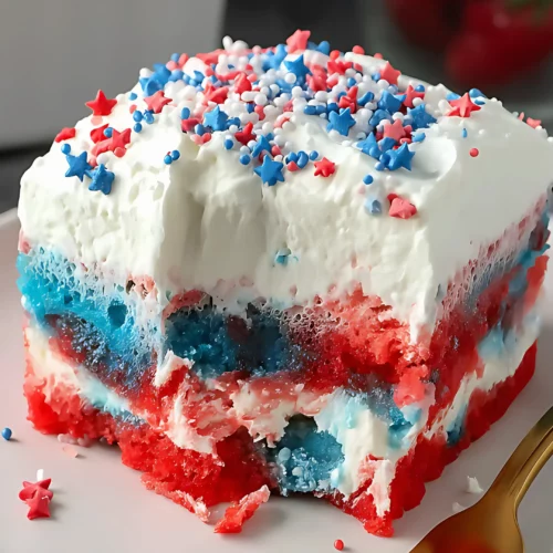 patriotic cake slice on red rimmed plate with gold fork