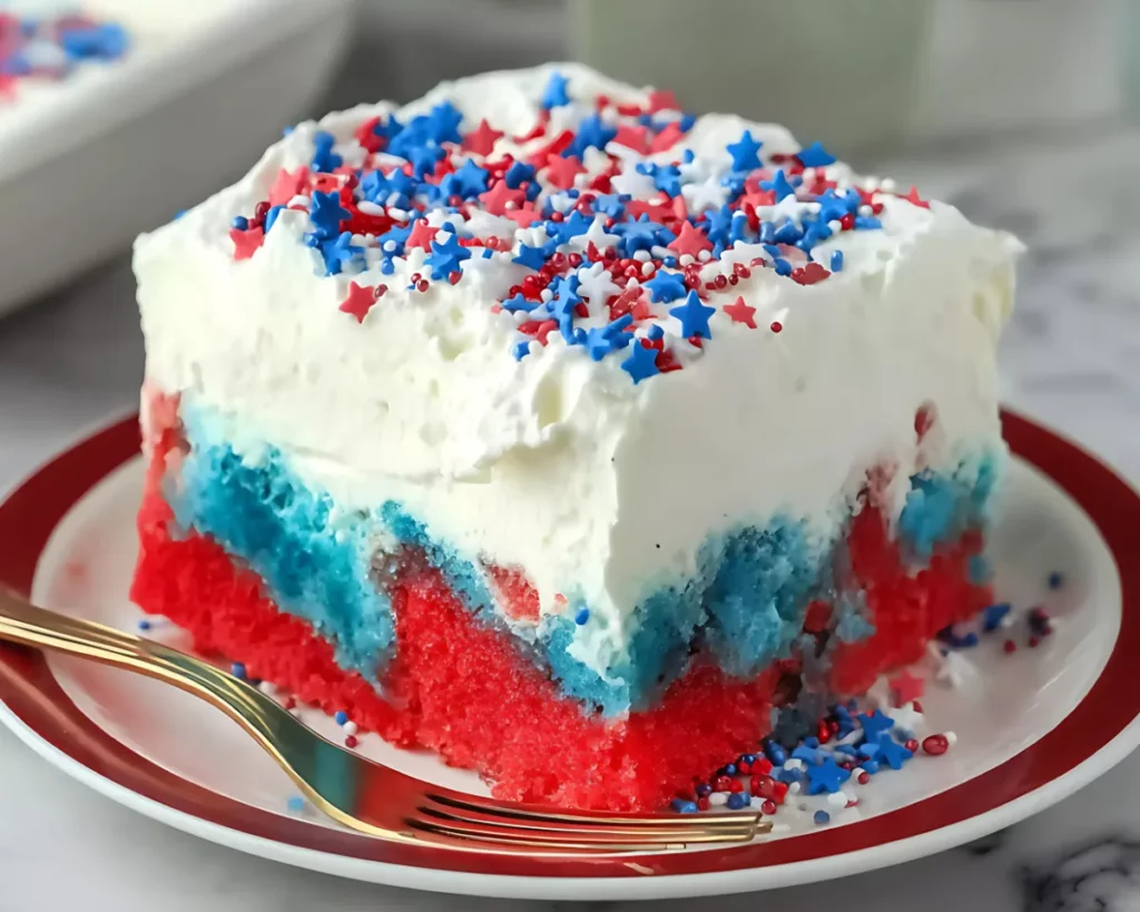 plated slice of patriotic cake with golden fork on marble table