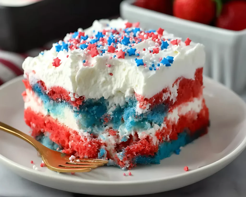 plated slice of patriotic cake with strawberries in background