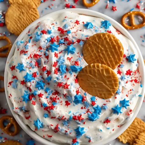 top view of patriotic dip in white bowl with cookies and pretzels