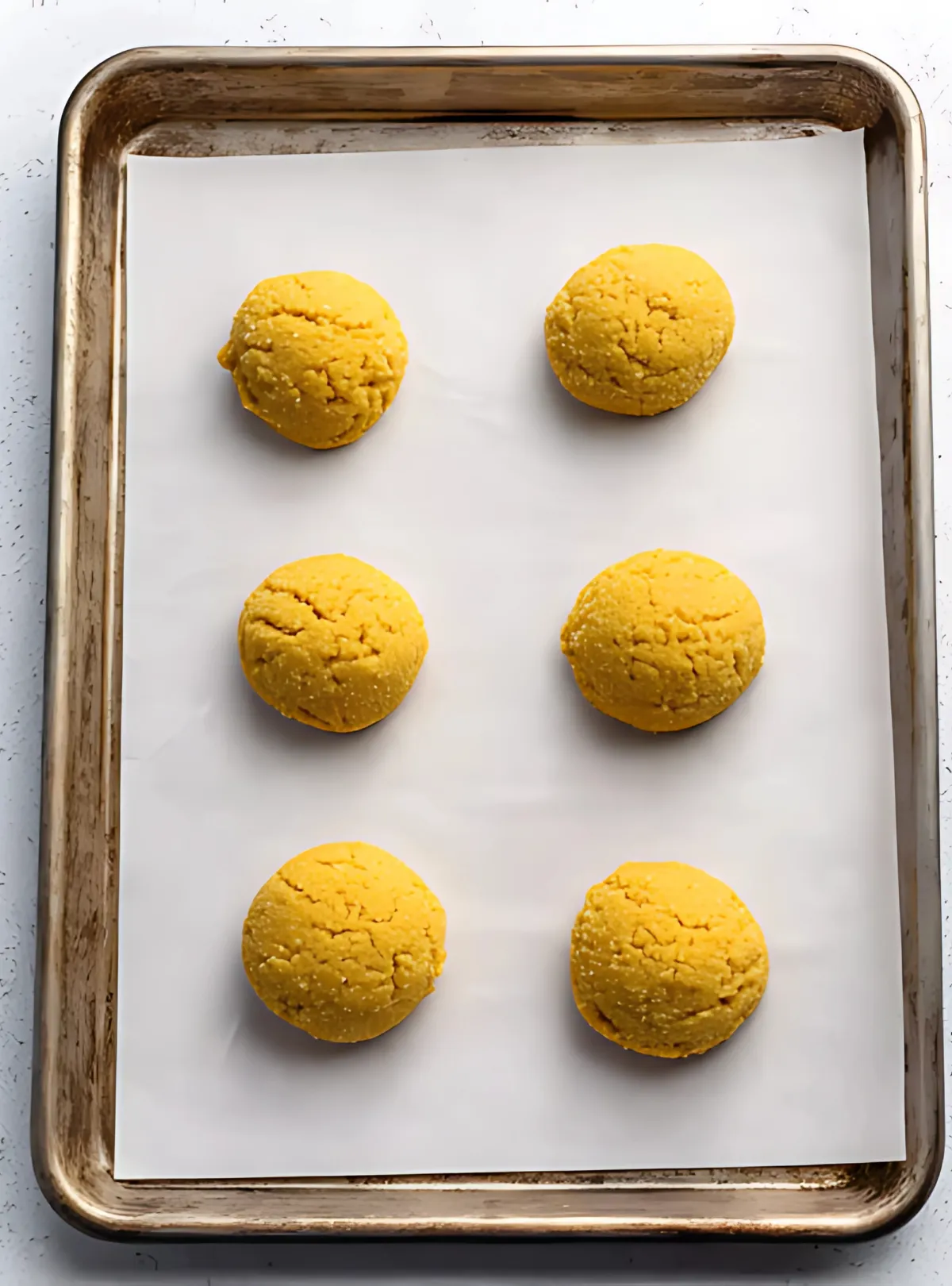 Raw cookie dough balls on baking sheet