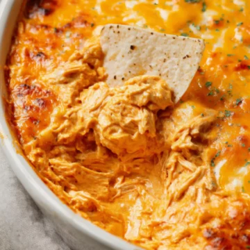 Hot buffalo chicken dip with melted cheese and tortilla chip