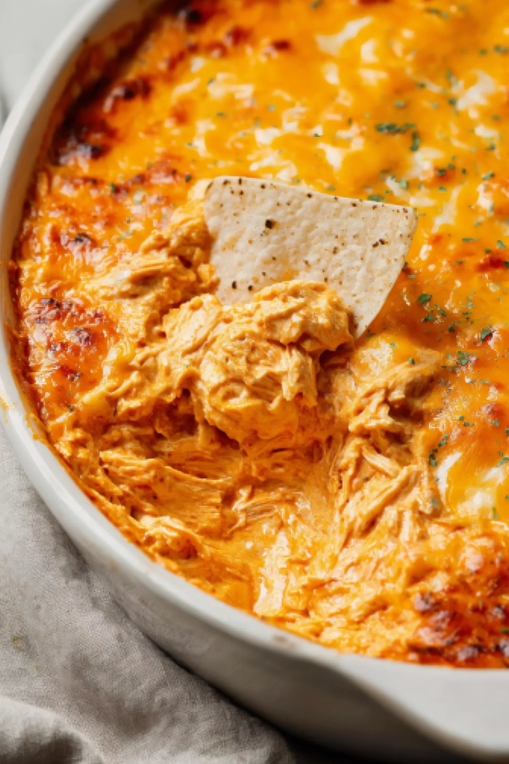 Hot buffalo chicken dip with melted cheese and tortilla chip