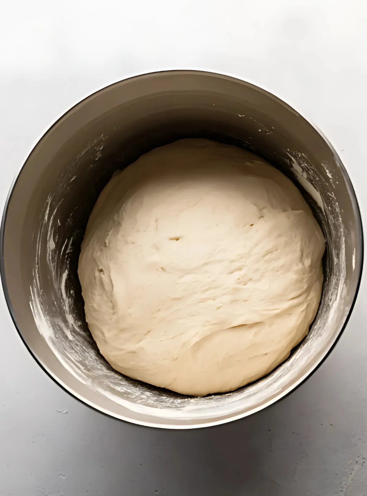 Pizza dough in a metal bowl
