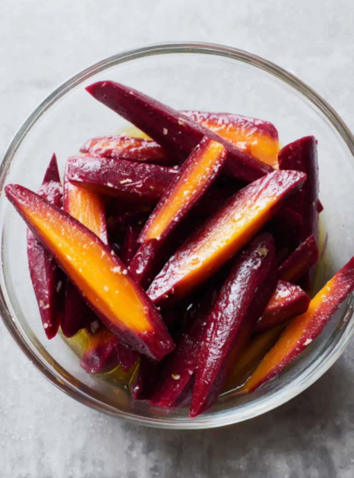 Raw purple carrots in glass bowl