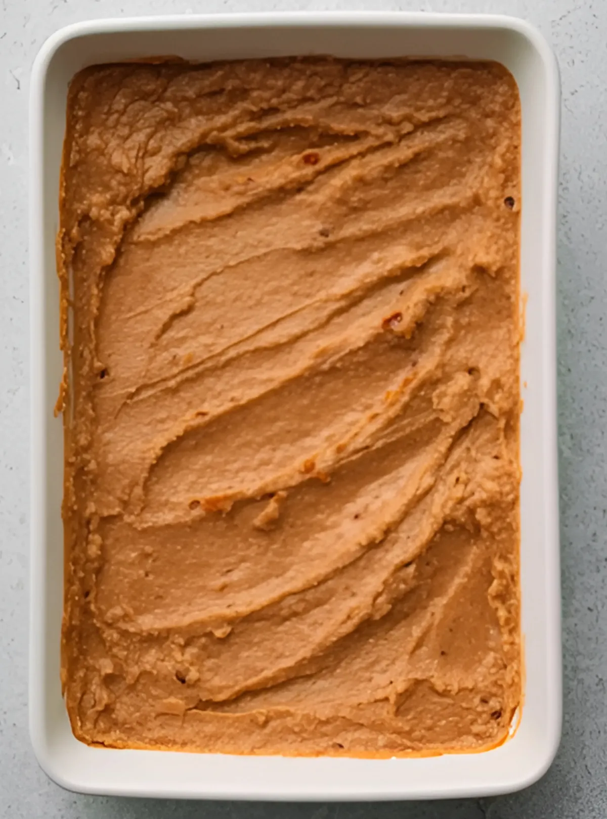 Refried beans layer in white dish
