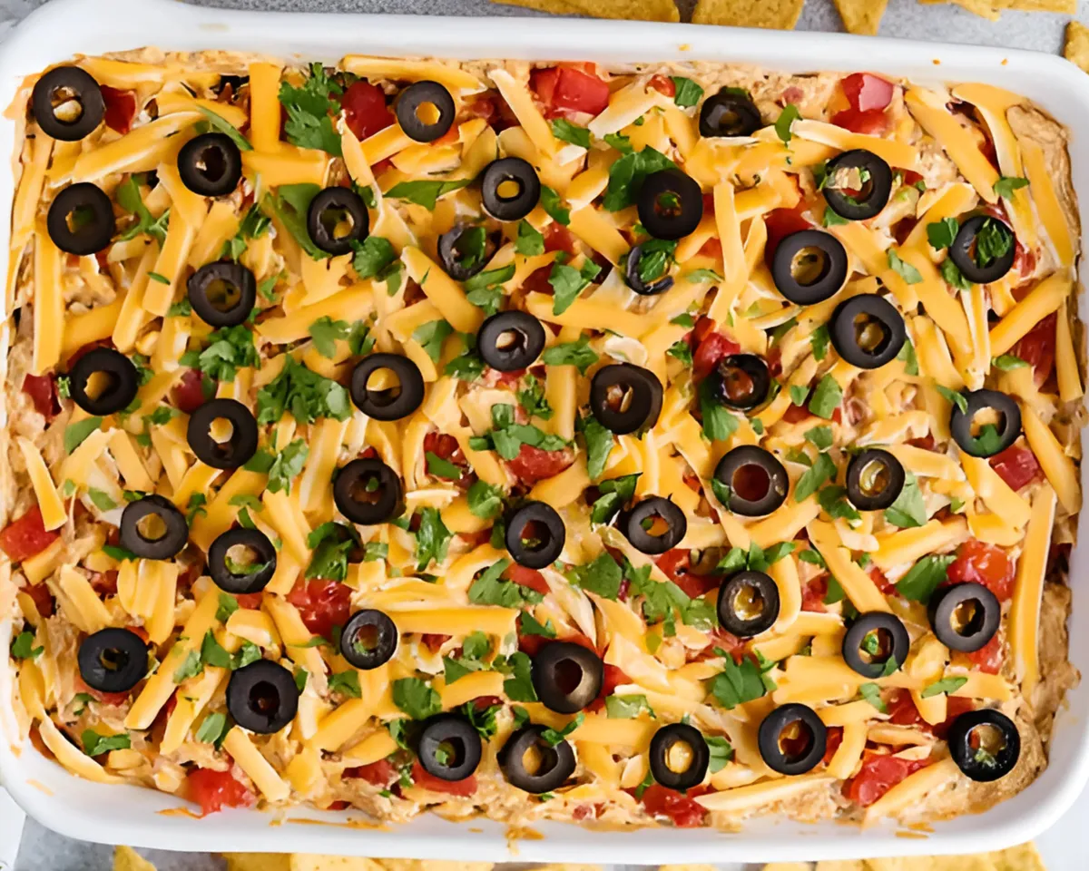 Taco dip in white dish topped with olives