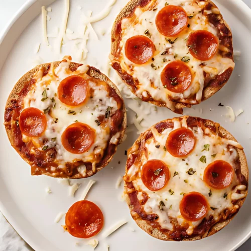 Three mini pepperoni pizzas on a white plate
