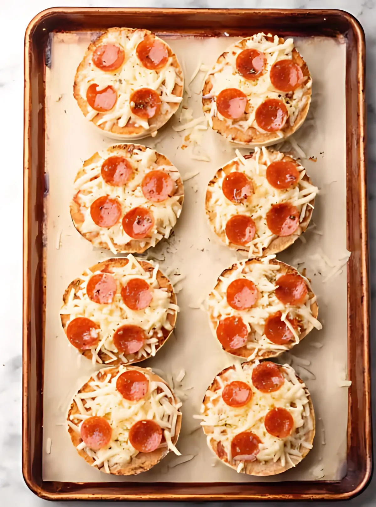 Unbaked pizzas with cheese and pepperoni on a sheet