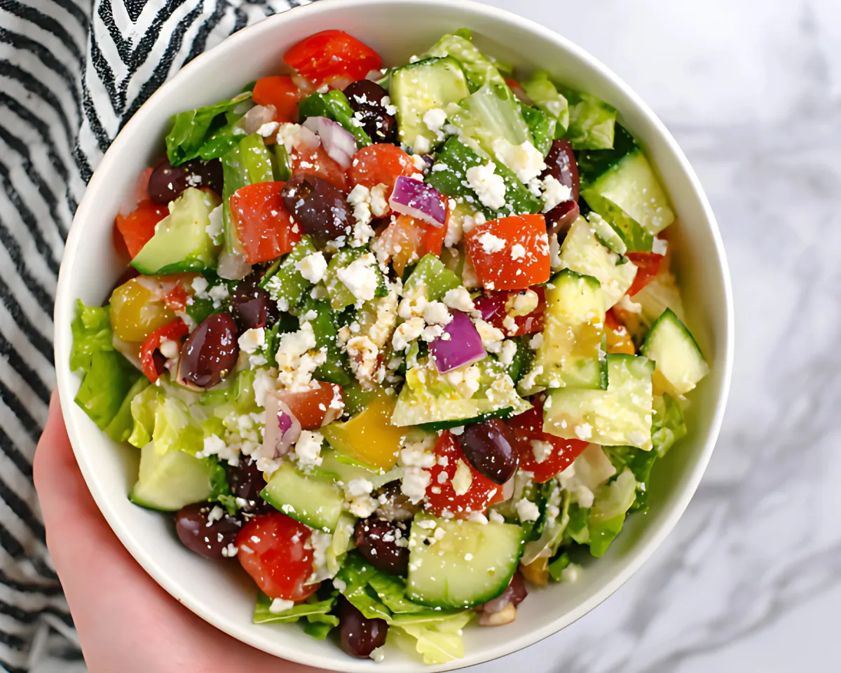 hand holding greek salad bowl