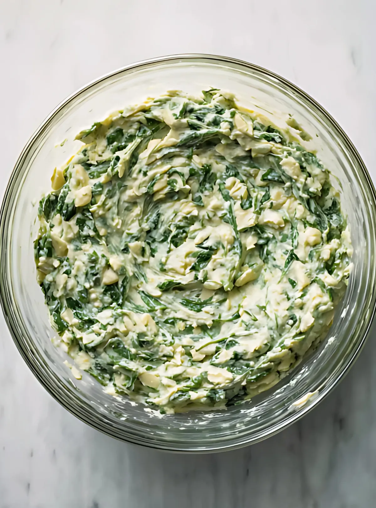 mixed spinach artichoke dip in glass bowl