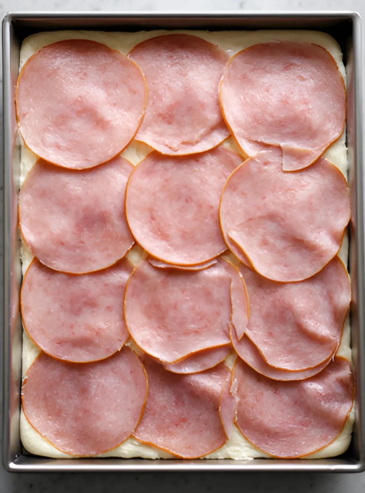 pizza dough with ham slices
