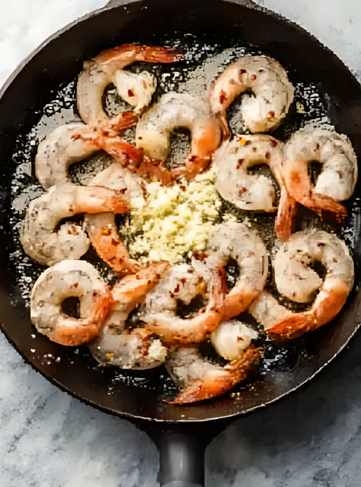 raw shrimp in pan with garlic