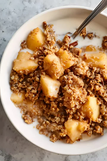 Apple crumble in bowl with milk