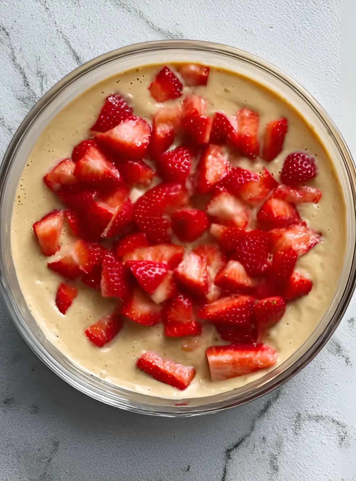 Batter topped with chopped strawberries