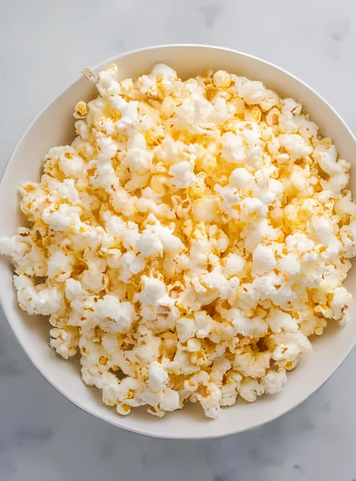 Bowl of plain popcorn on marble surface
