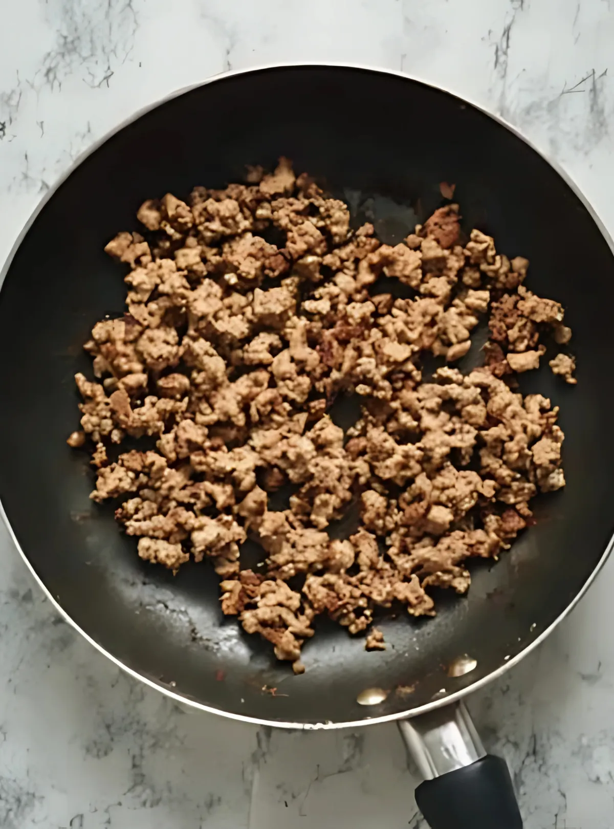 Browned sausage crumbles in skillet