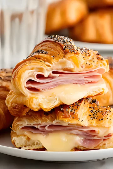 Croissant sandwich stacked with ham and melted cheese