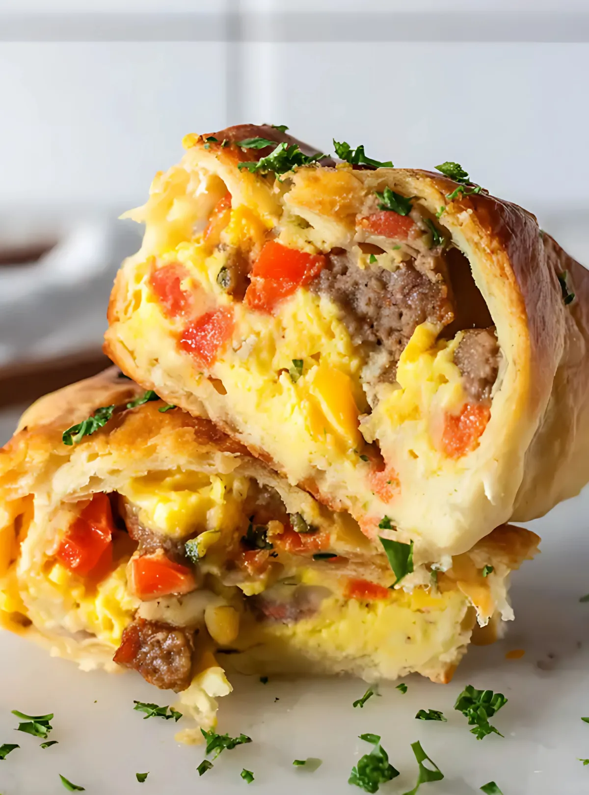 Halved breakfast roll filled with sausage egg cheese and red pepper