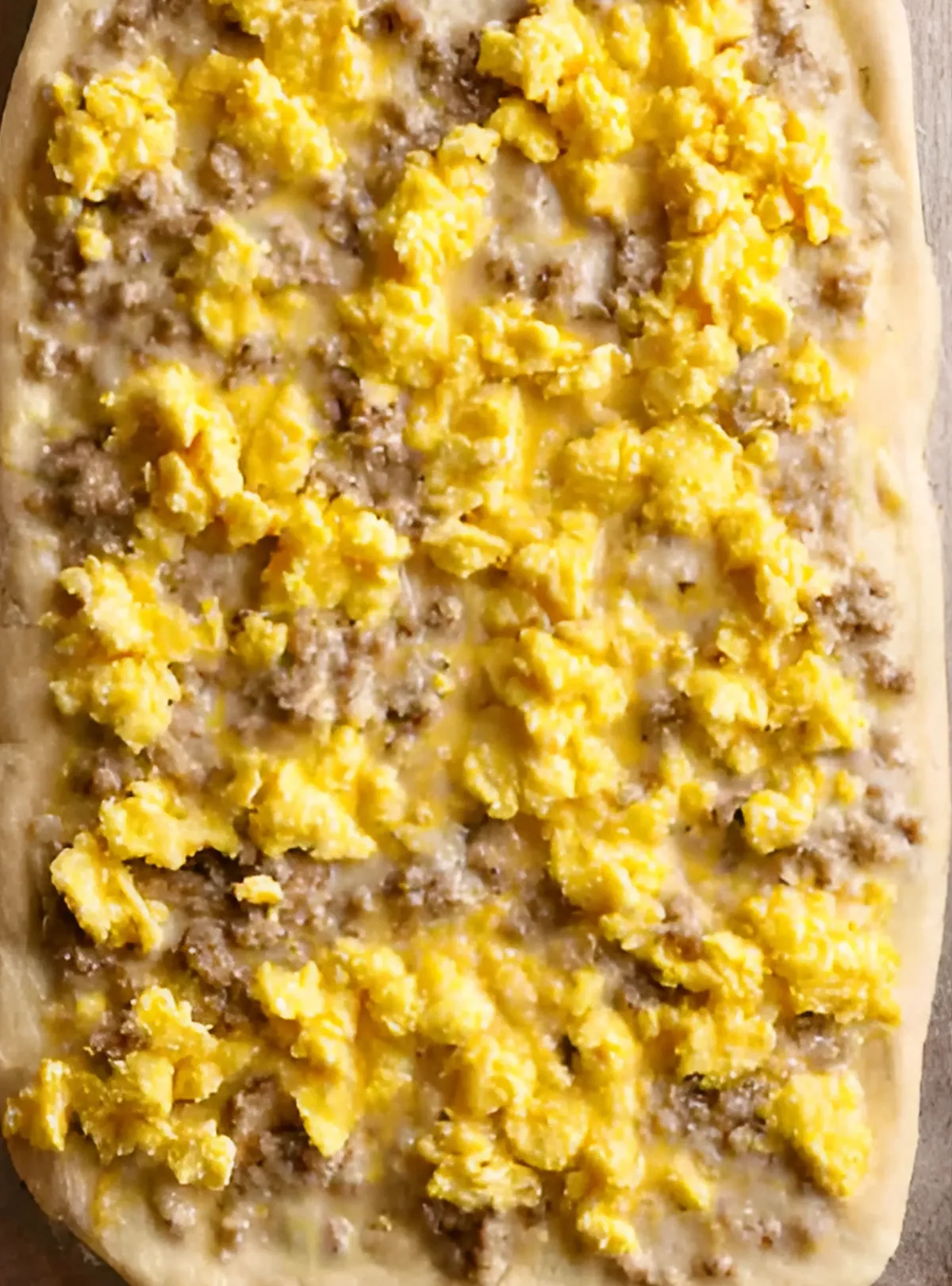 Pizza with eggs and sausage before cheese