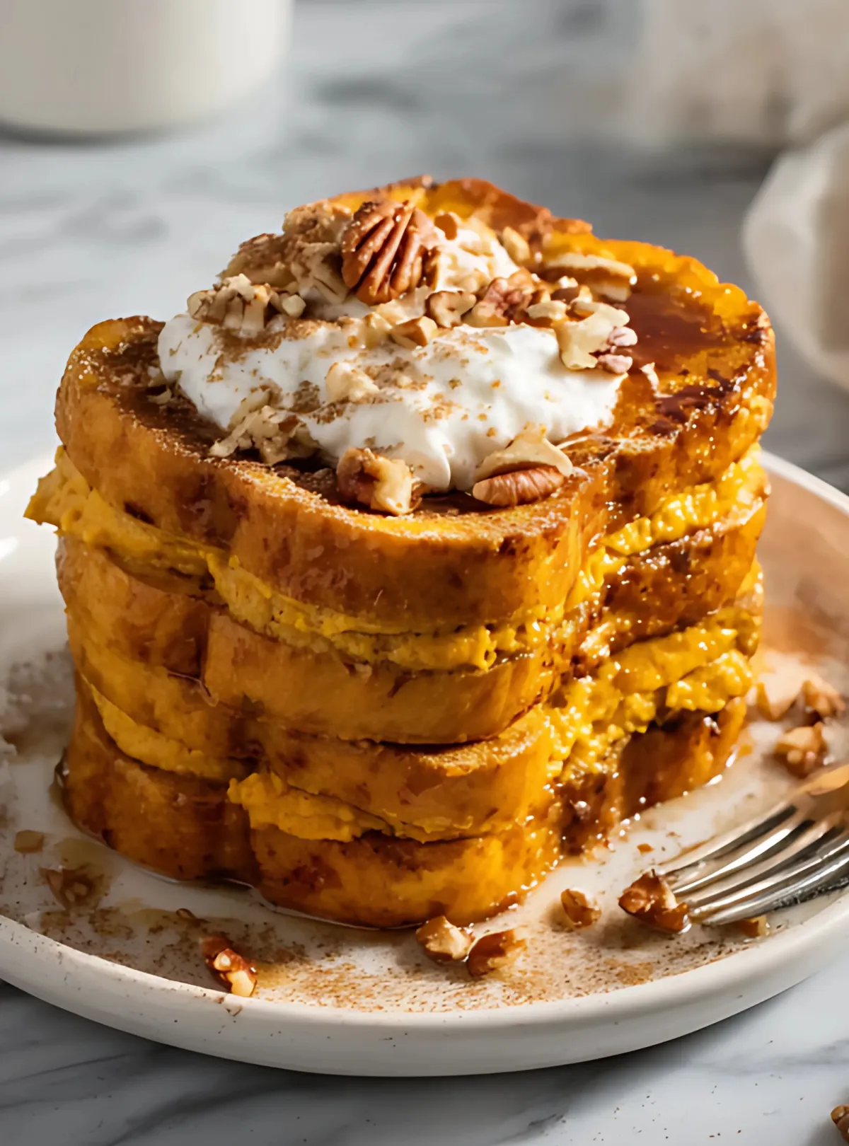 Pumpkin french toast stack topped with cream and pecans