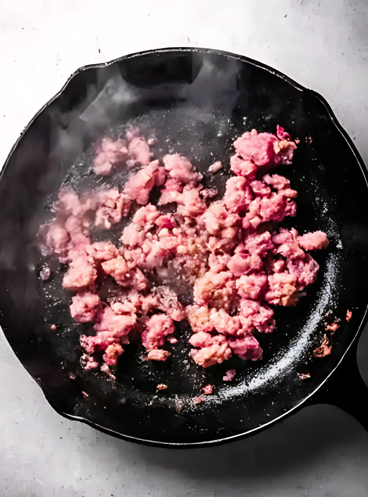 Raw sausage cooking in skillet