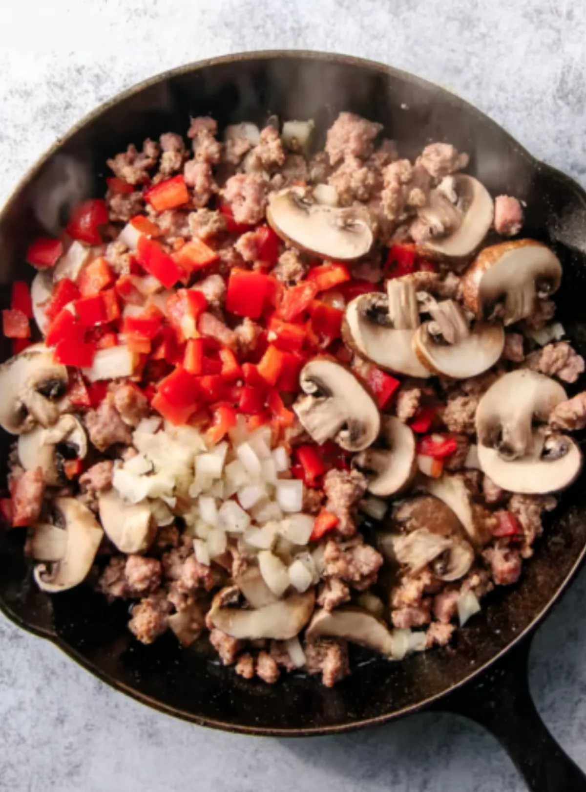 Sausage onion pepper mushroom in skillet