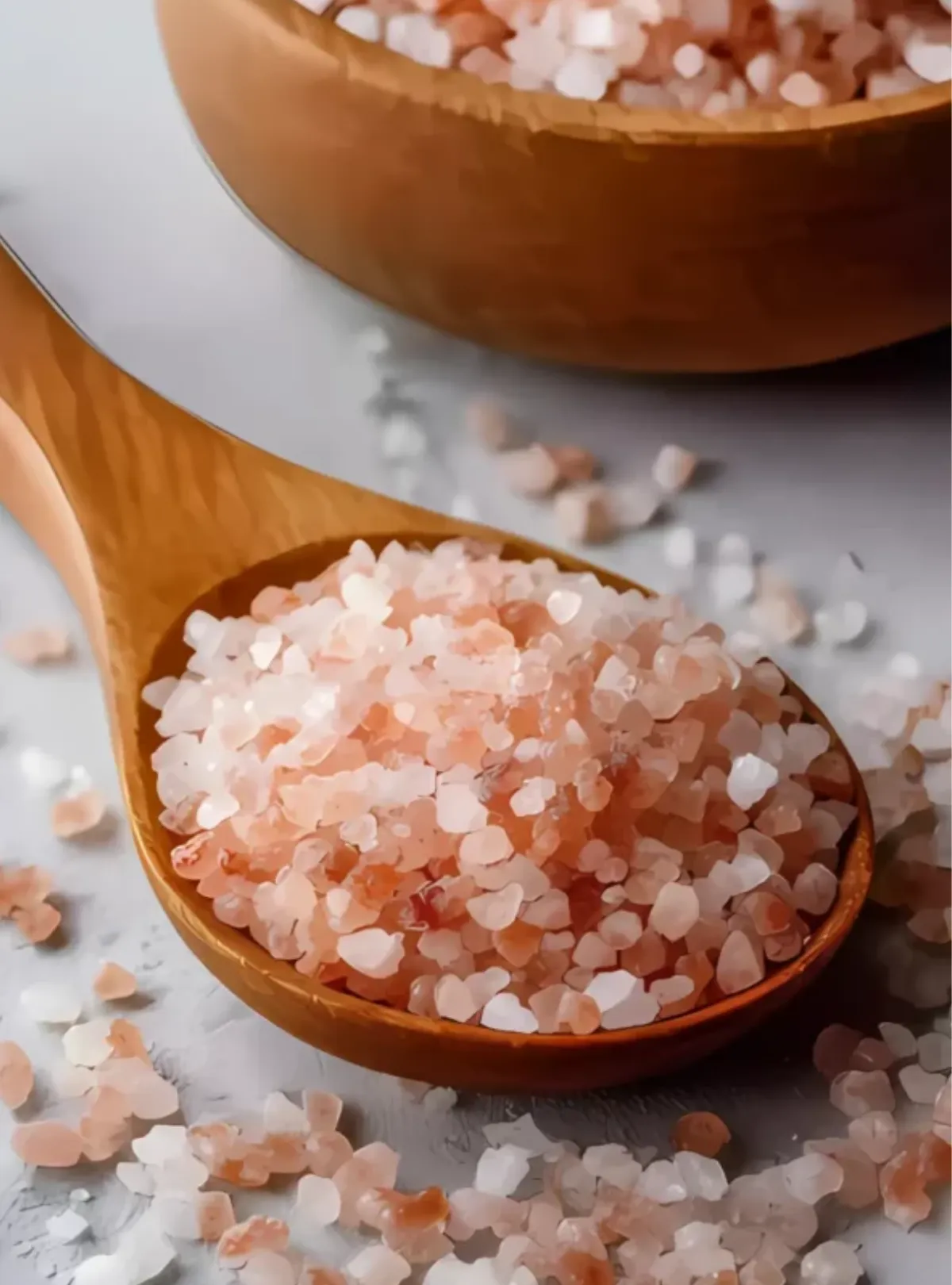 Wooden spoon with pink Himalayan salt in bowl