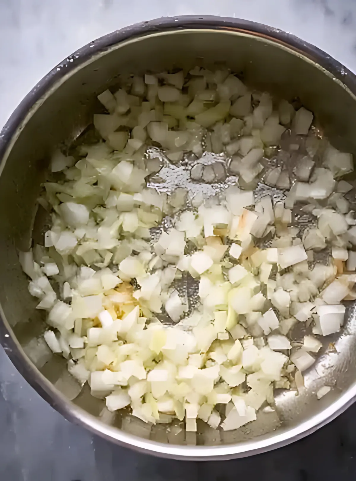 chopped onion cooking in butter inside pot