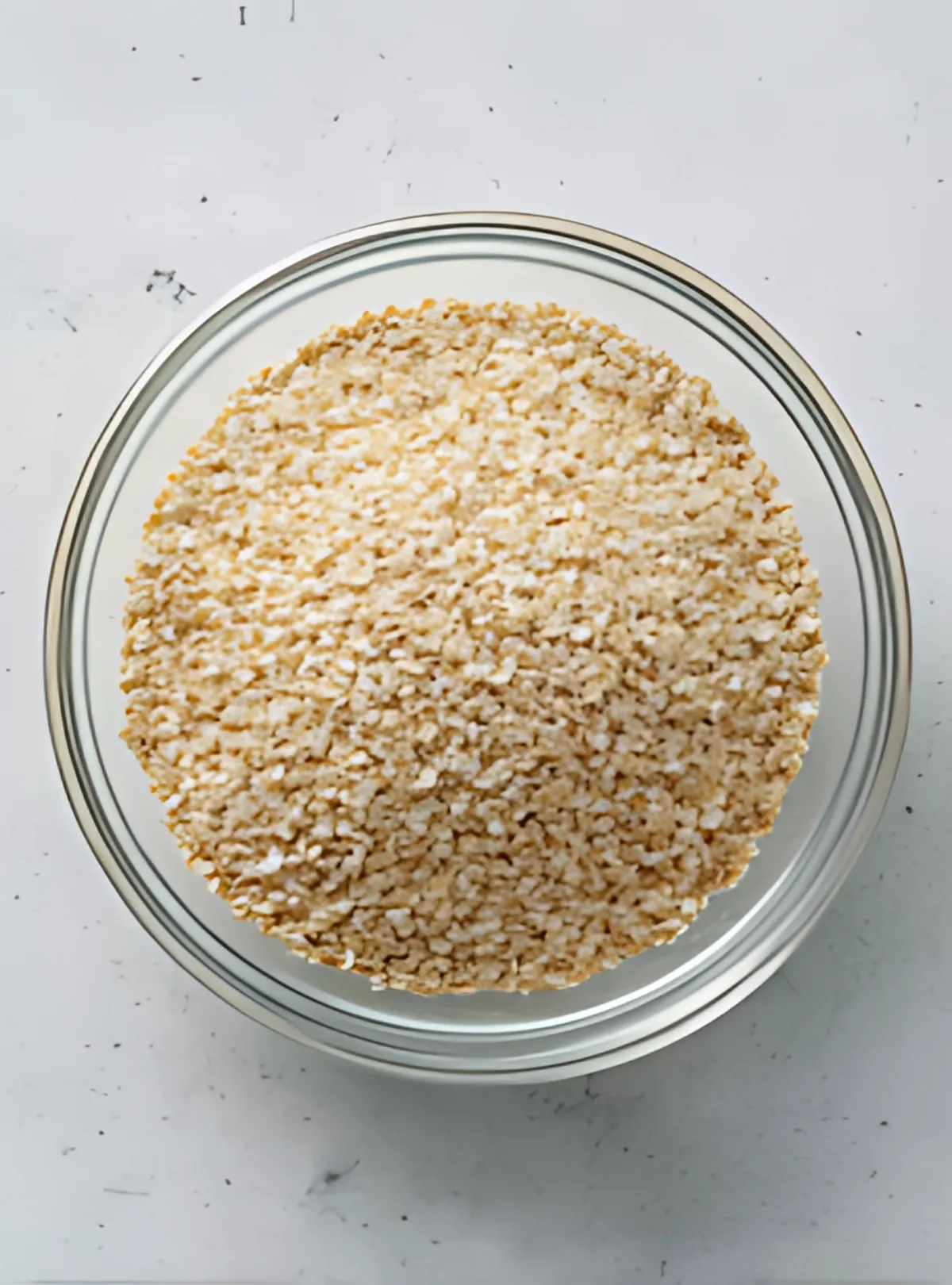 dry steel cut oats in a glass bowl on white surface