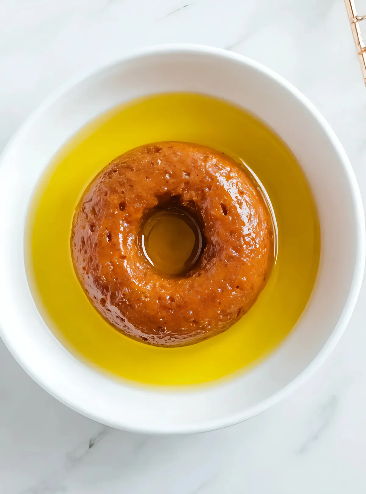 Donut sitting in bowl of melted butter or oil